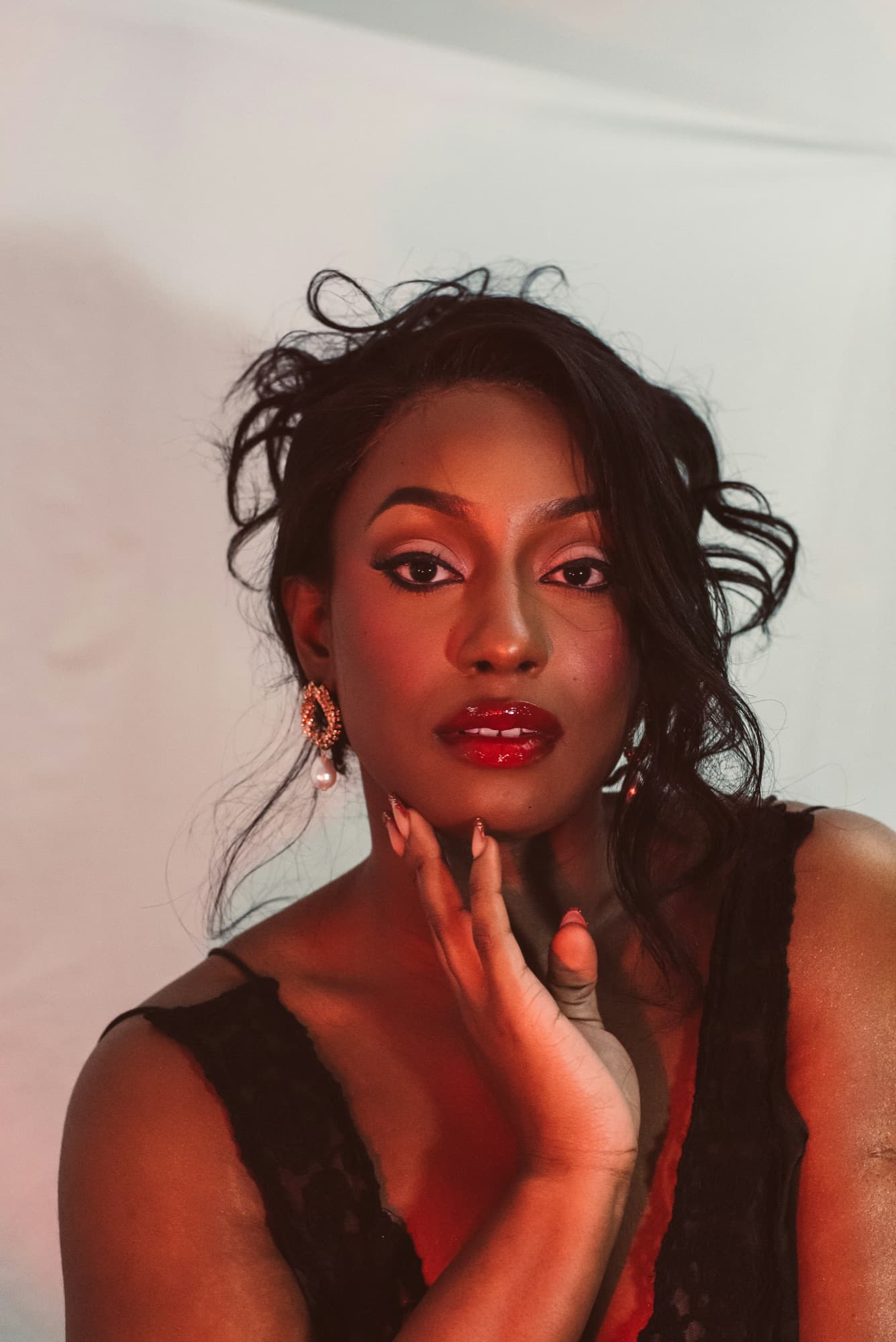 Femme aux ongles manucurés, la main posée contre le visage